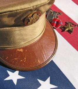 Military cap over American Flag honoring those who've served our nation.