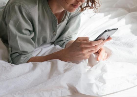 woman using a smartphone in bed